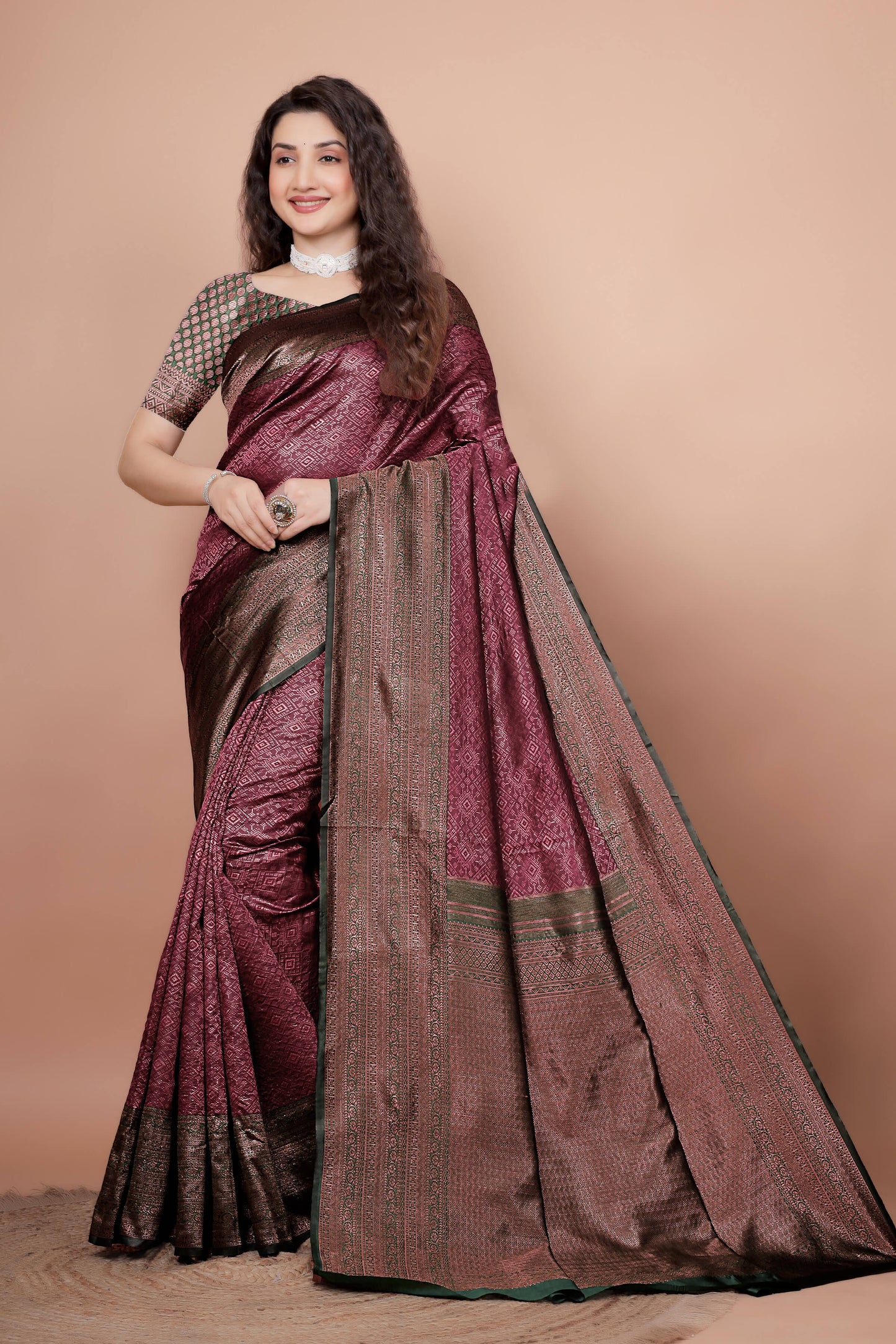 Woman modeling a beautiful maroon and green woven silk saree