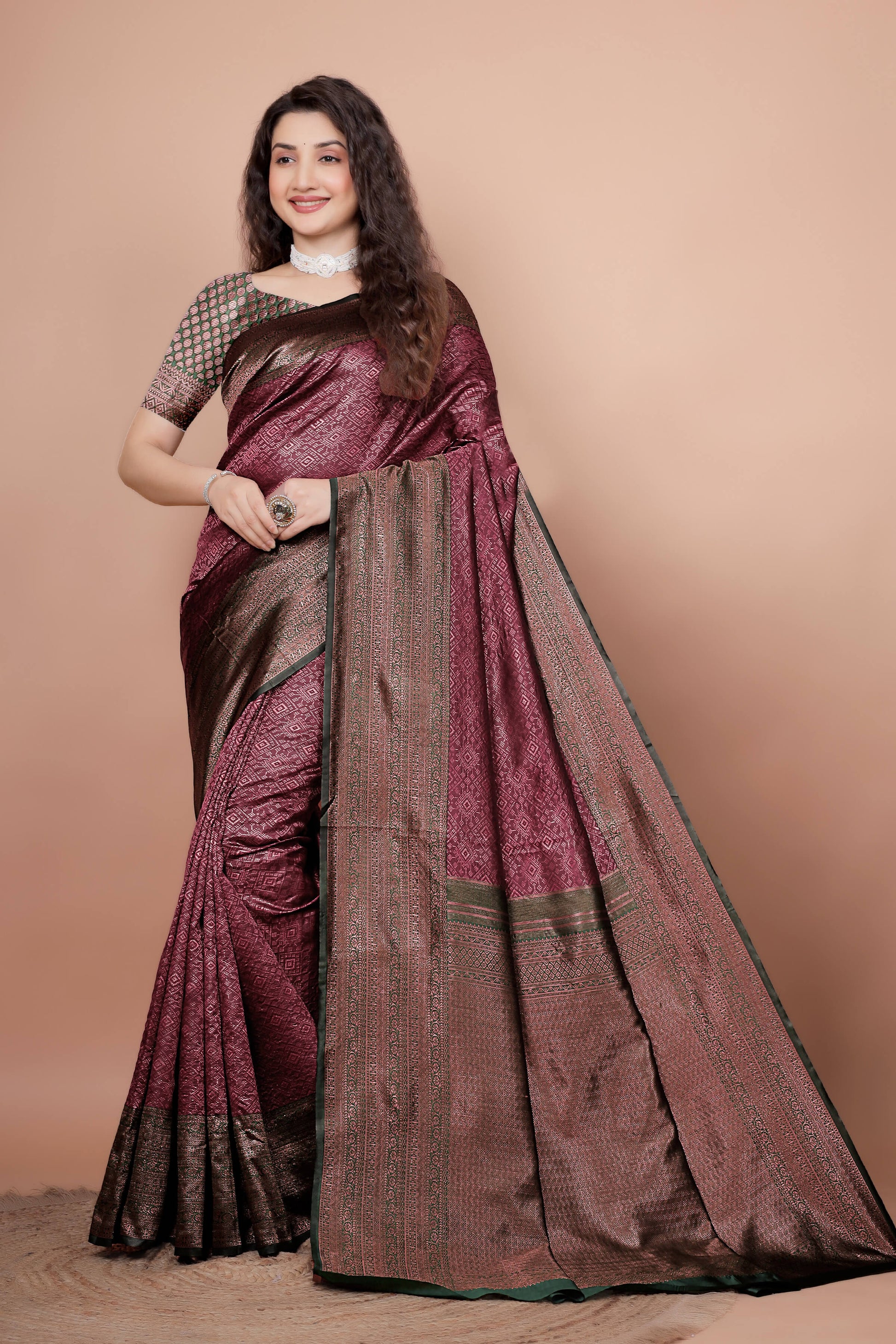Woman modeling a beautiful maroon and green woven silk saree
