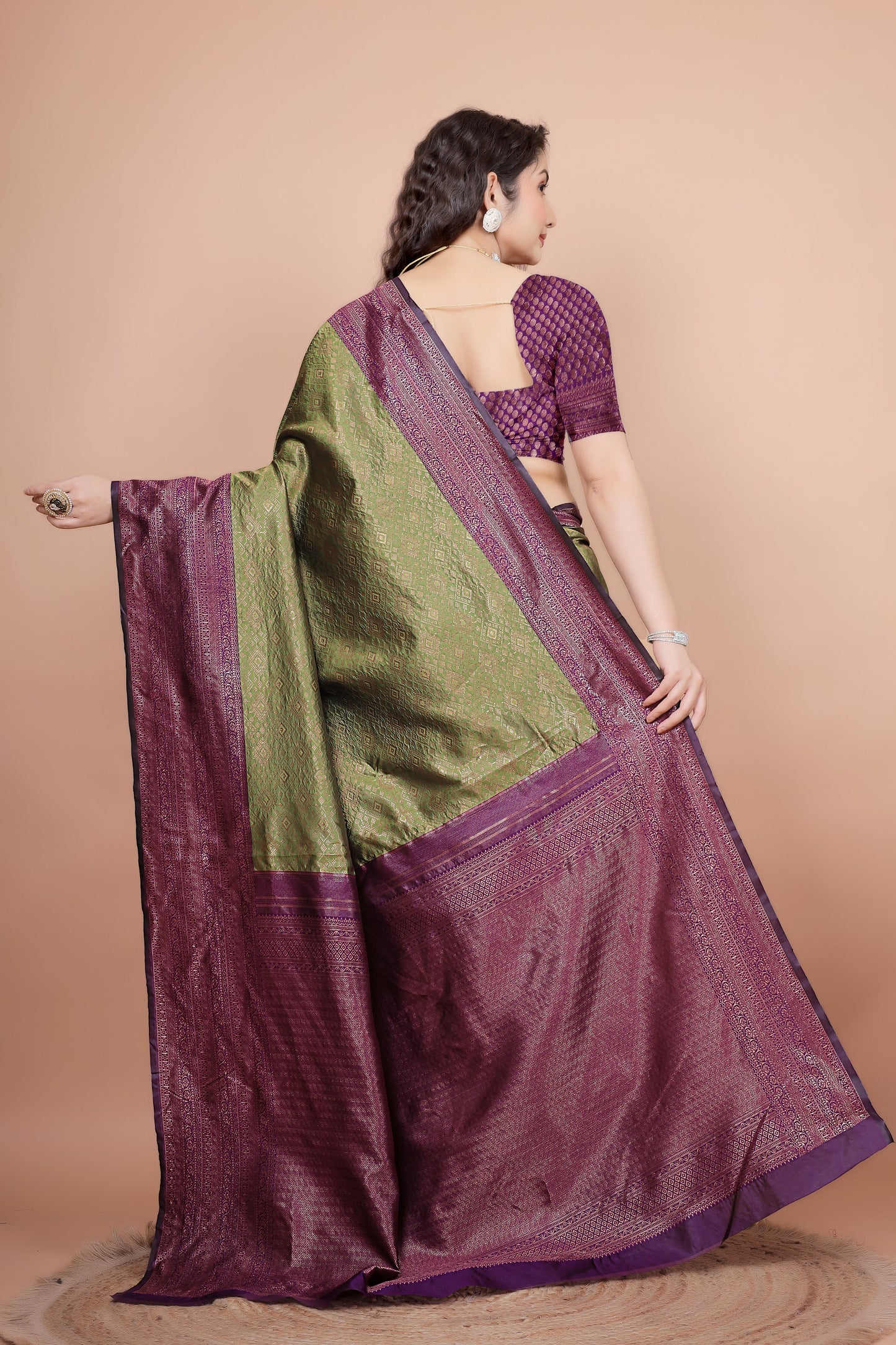 Back view highlighting the textured cherry blouse and the flowing woven pallu
