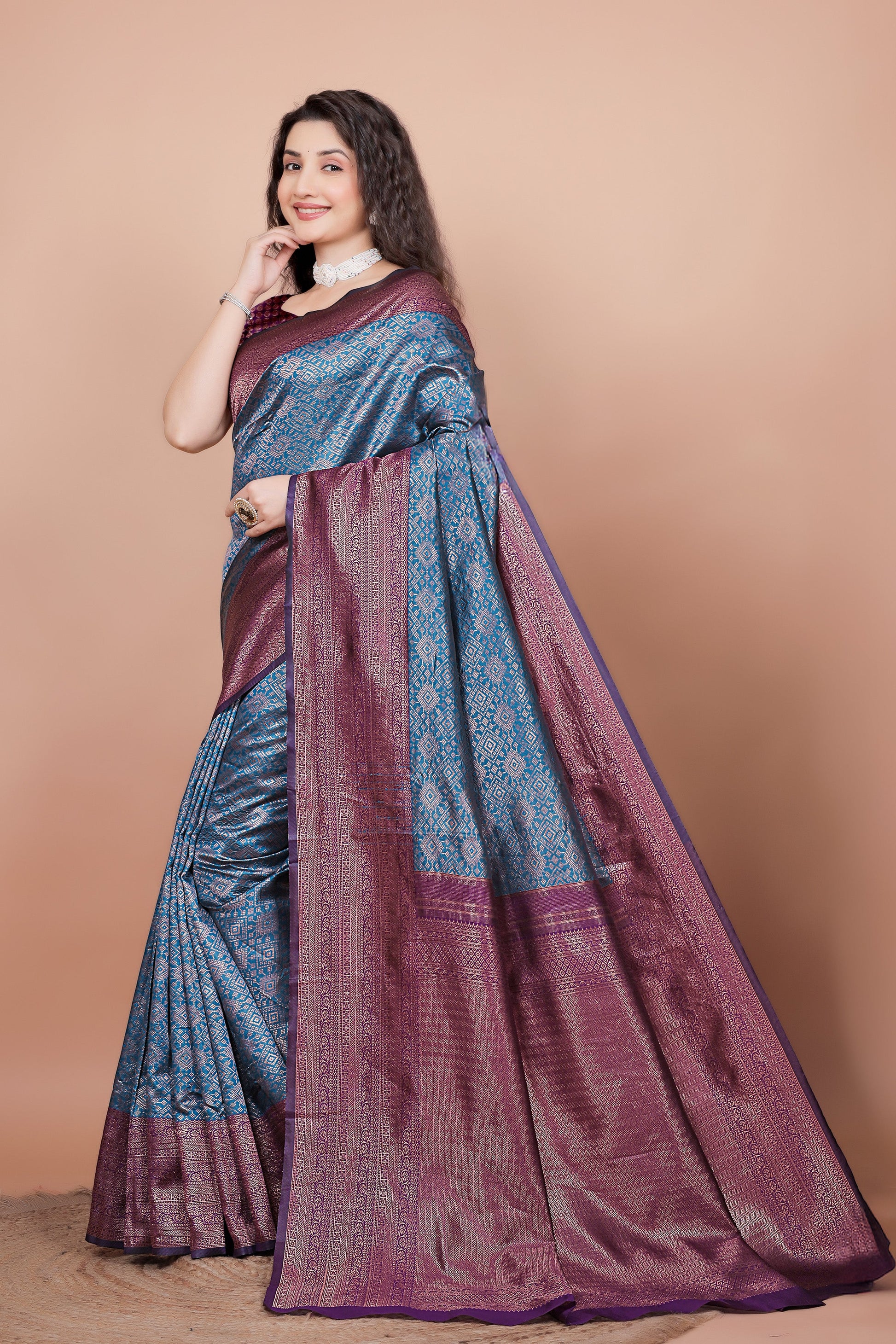 Side angle showcasing the rich wine pallu and peacock blue pleats