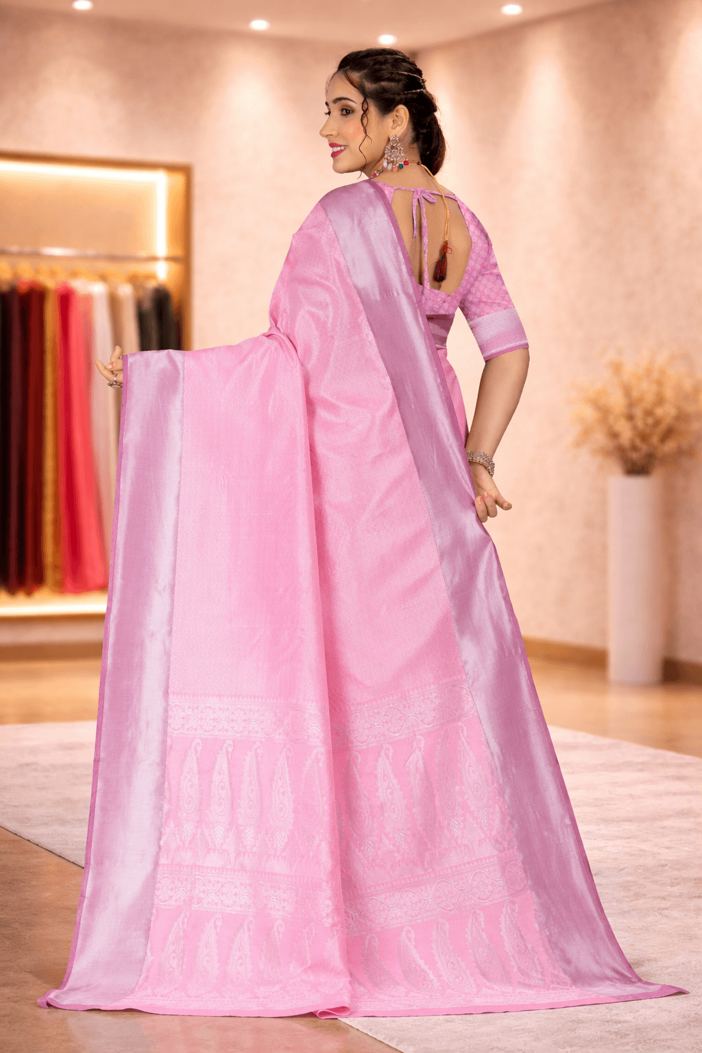 Back view highlighting the intricate paisley woven pallu and blouse design of the pink silk saree