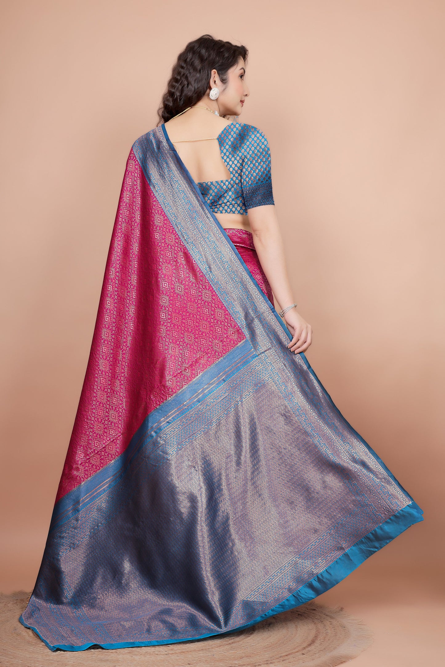 Back view of the rani pink saree drape and matching peacock blue woven blouse design