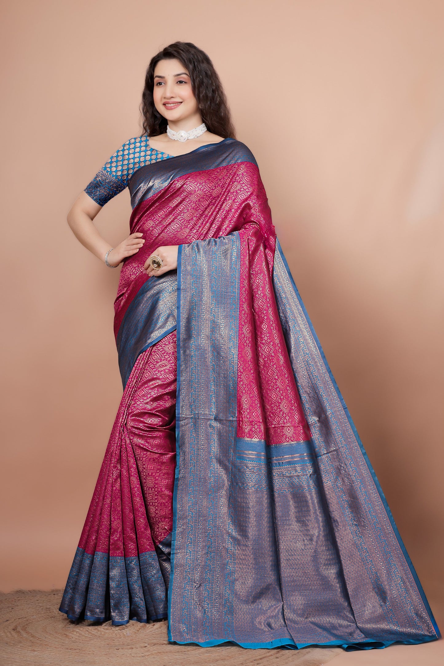 Model elegantly posing in a vibrant rani pink and peacock blue woven silk saree