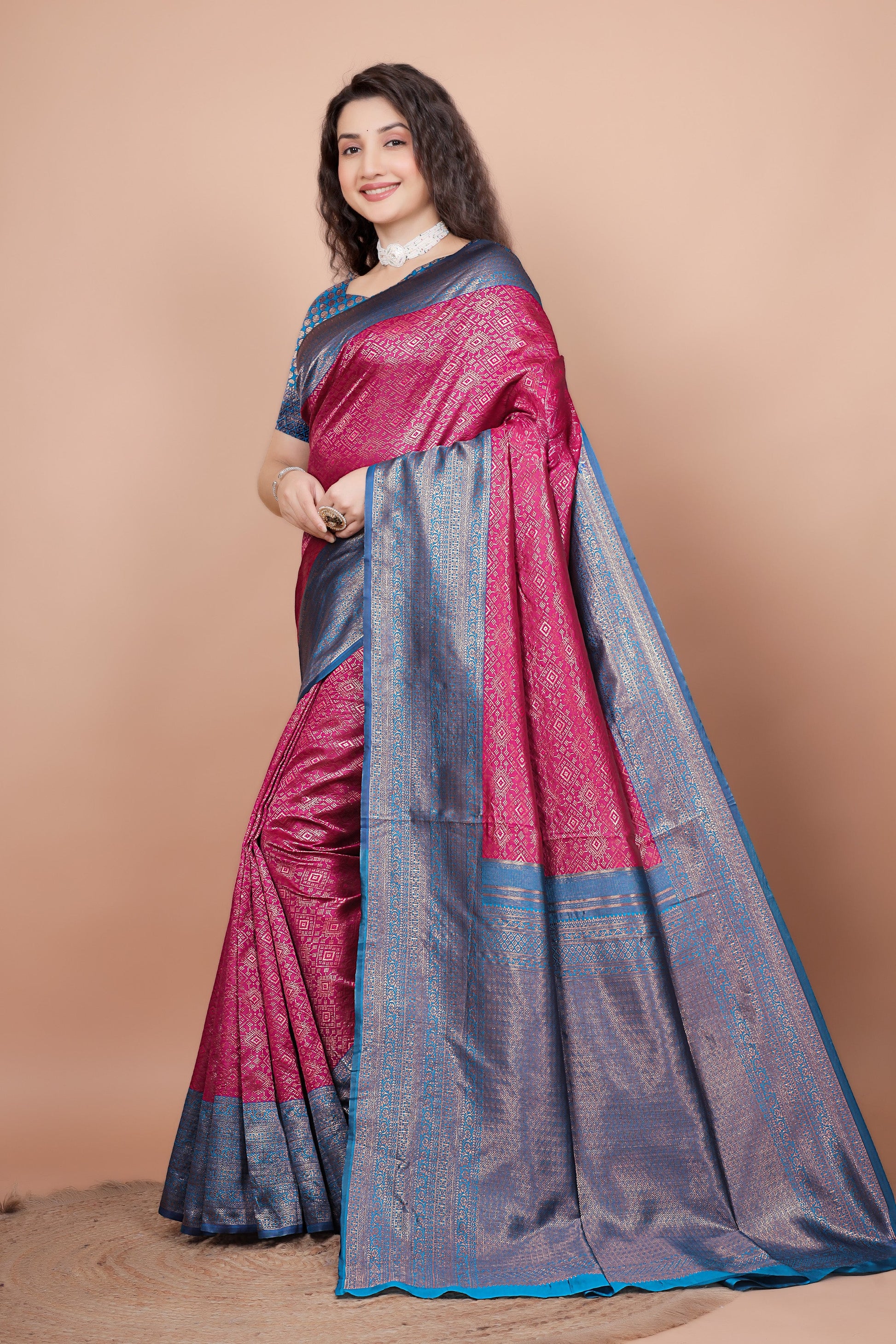 Side view of the rani pink saree displaying the detailed peacock blue pallu and pleats