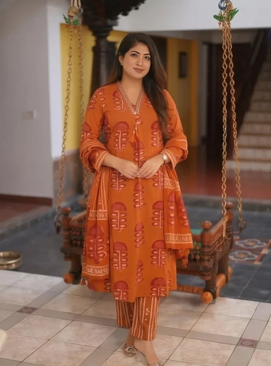 Full-length front view of a woman wearing a rust orange pure cotton suit set featuring bold block prints and striped pants.