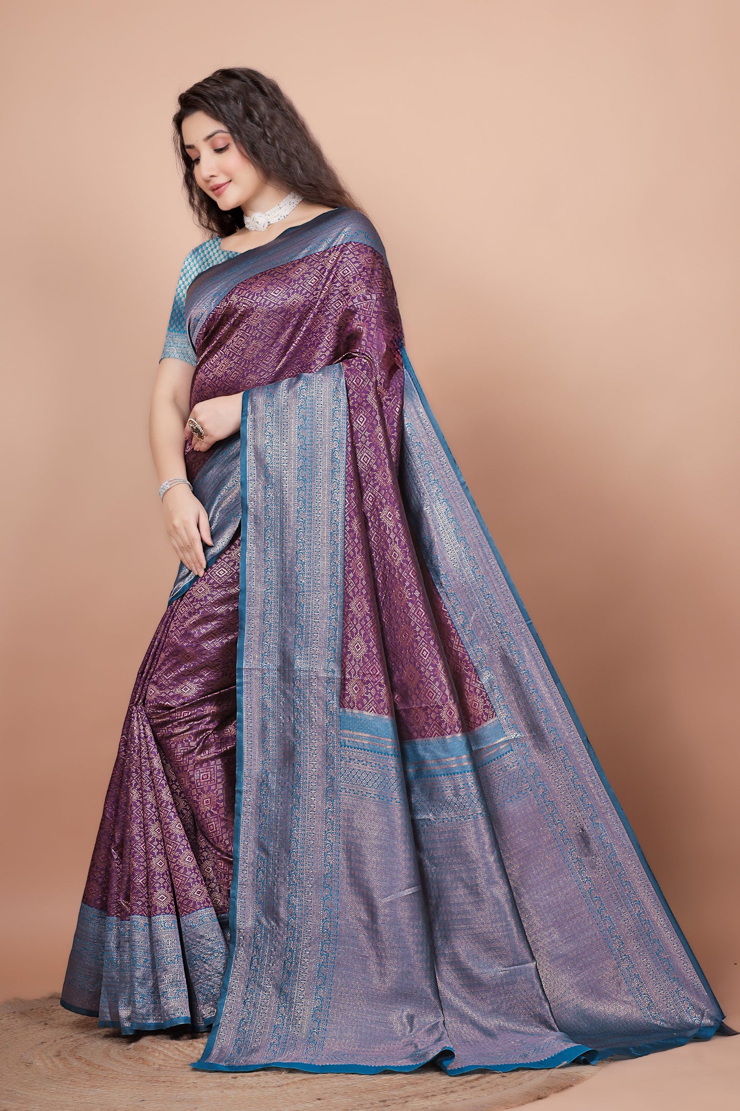 Side angle showcasing the contrasting peacock blue pallu and rich wine pleats