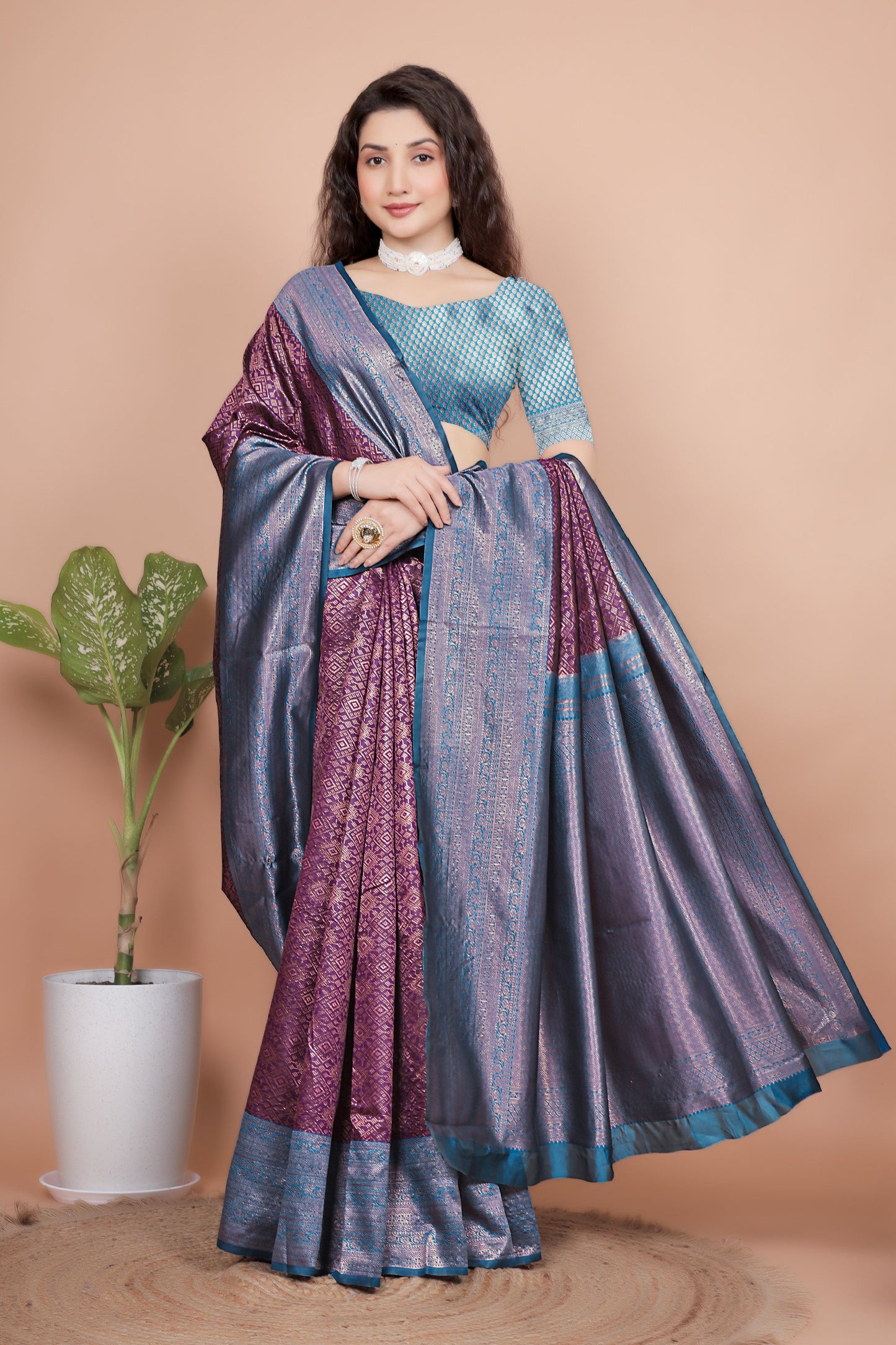 Model elegantly draped in a wine and teal silk saree posing gracefully